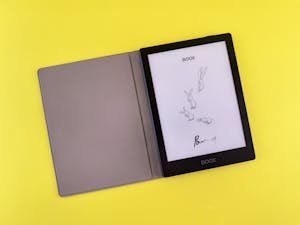 E-reader with bunny drawing on screen, placed on a vibrant yellow background, displaying artistic style.