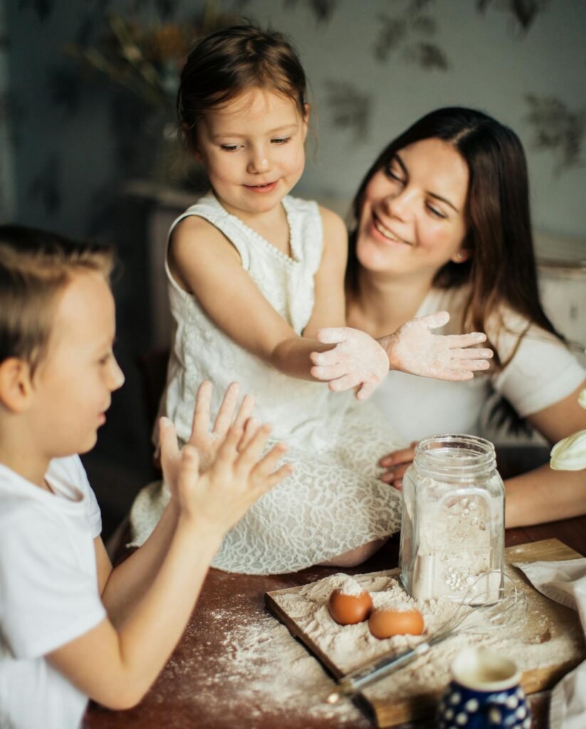 A joyful family moment with mother and children baking together in a cozy kitchen atmosphere.