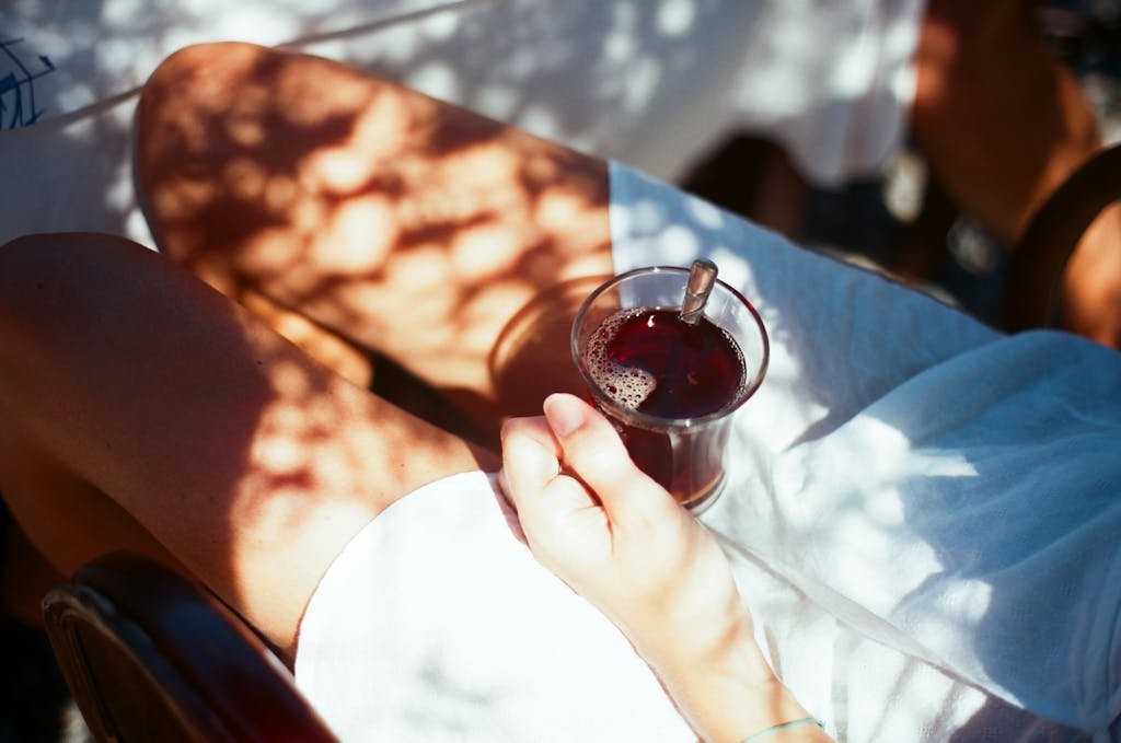 A person enjoying a cup of tea in the sun, creating a serene and tranquil moment.