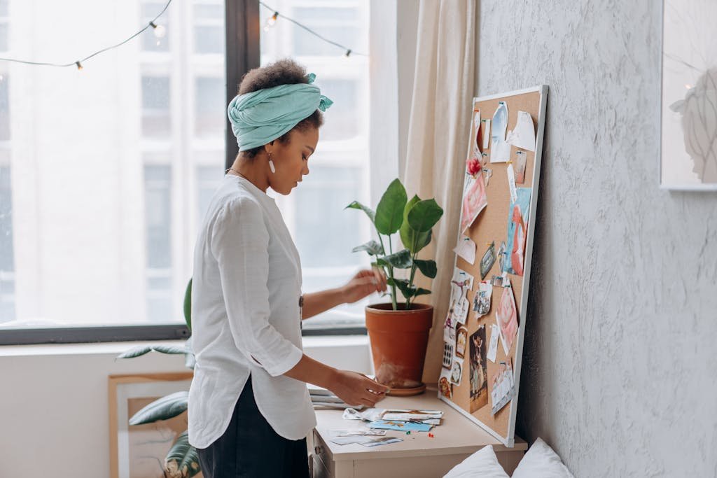 Young woman with headscarf creating a vision board indoors. Inspiring workspace for creativity.