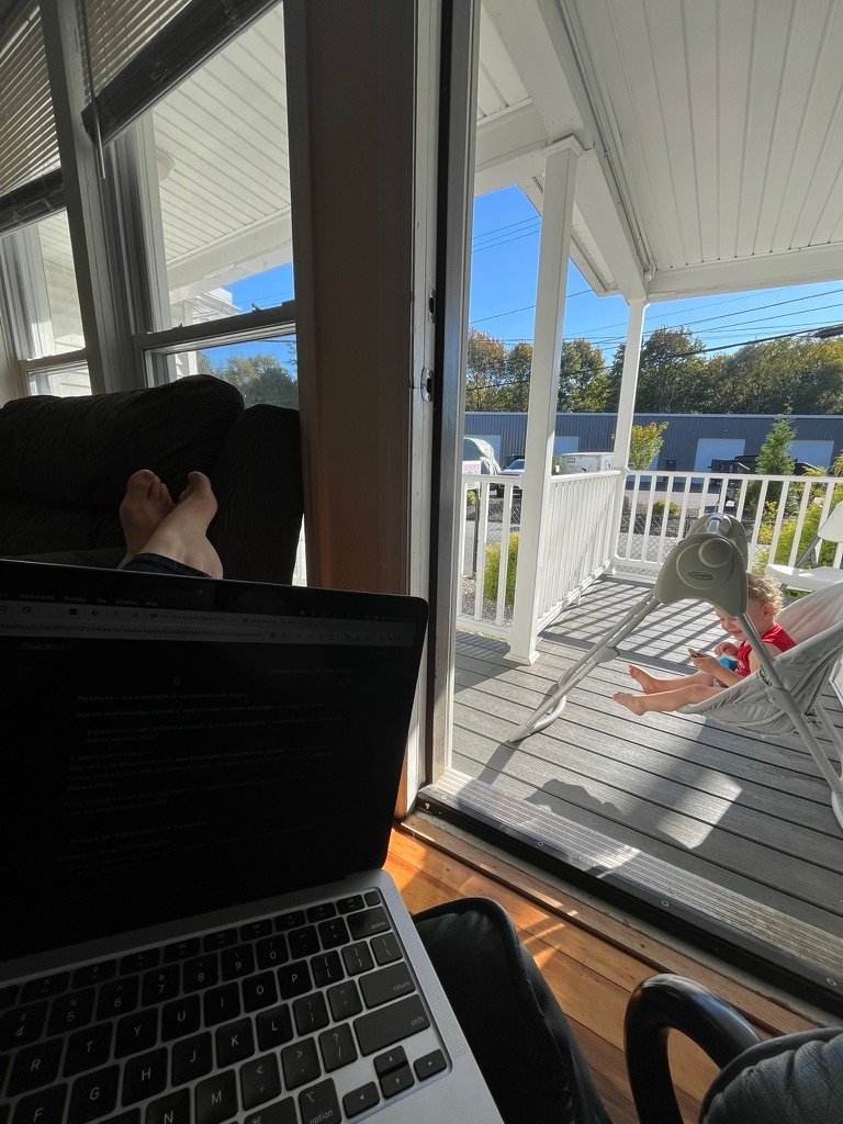 Woman working from home while her son plays in the deck.