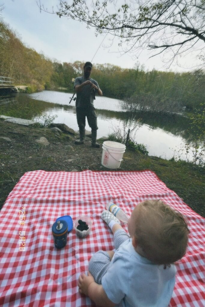 Man fishing while son looks at him