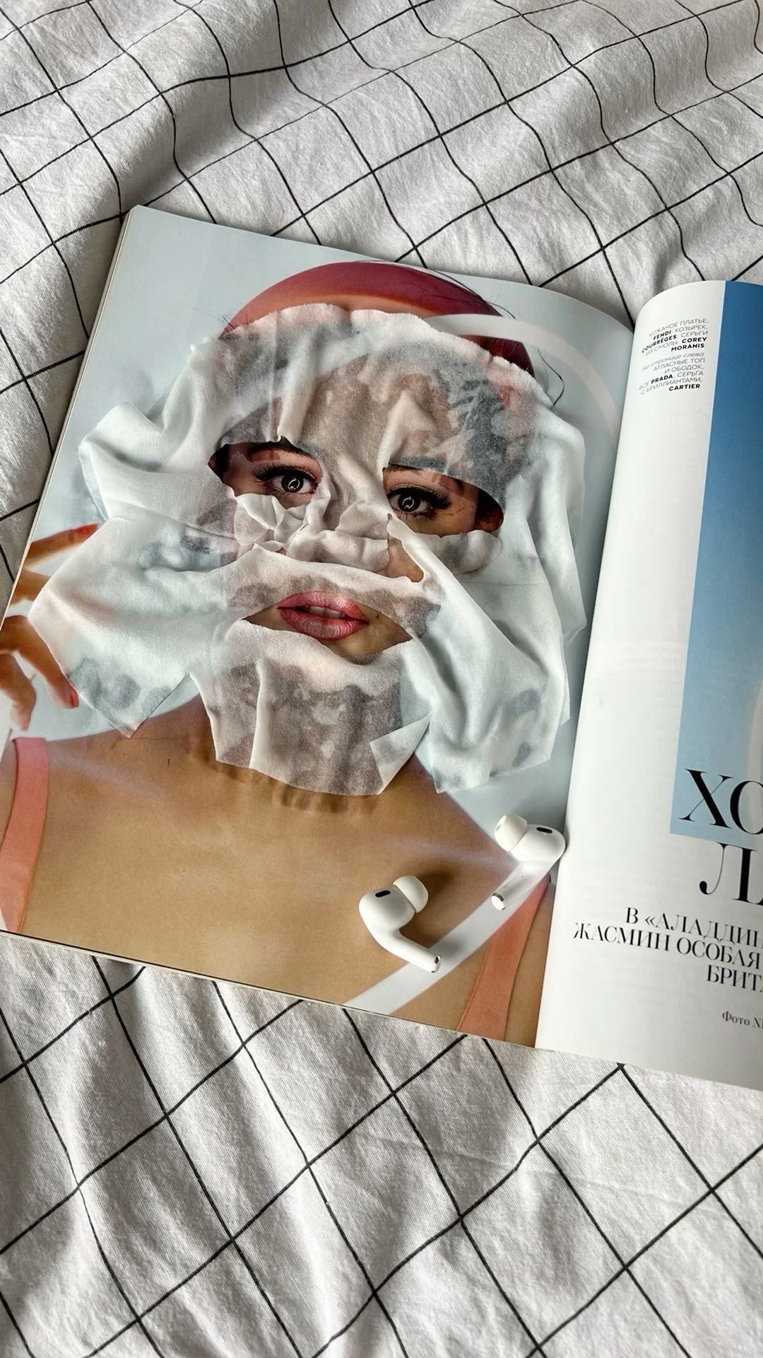 Aesthetic self-care moment with a sheet face mask, magazine, and wireless earbuds, representing intentional routines and personal rebranding.