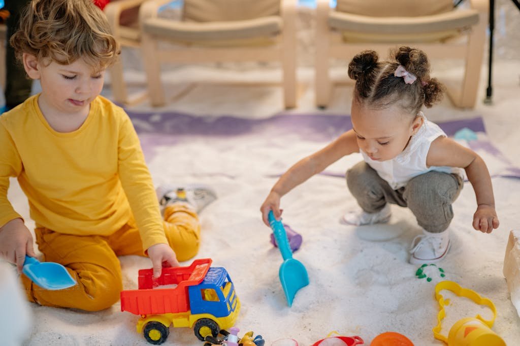 Two young children playing with toys in an indoor setting, fostering creativity and teamwork.