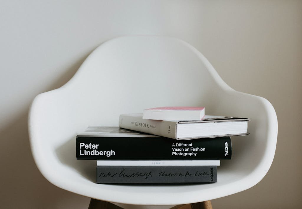 Minimalist composition of stacked books on a sleek modern chair, ideal for home decor inspiration.