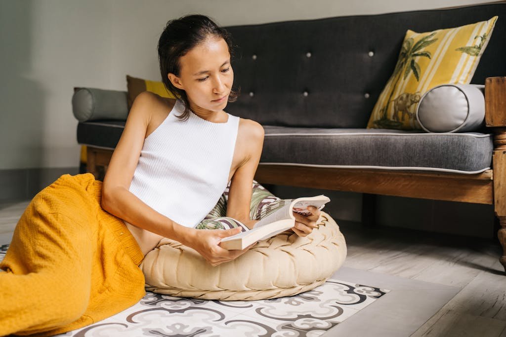 Young woman enjoying a relaxing moment reading a book indoors.