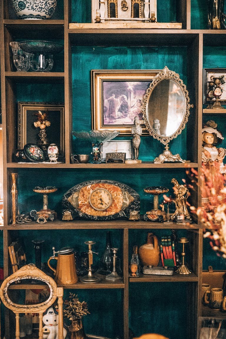 A curated display of antique items on ornate wooden shelves in an indoor setting.