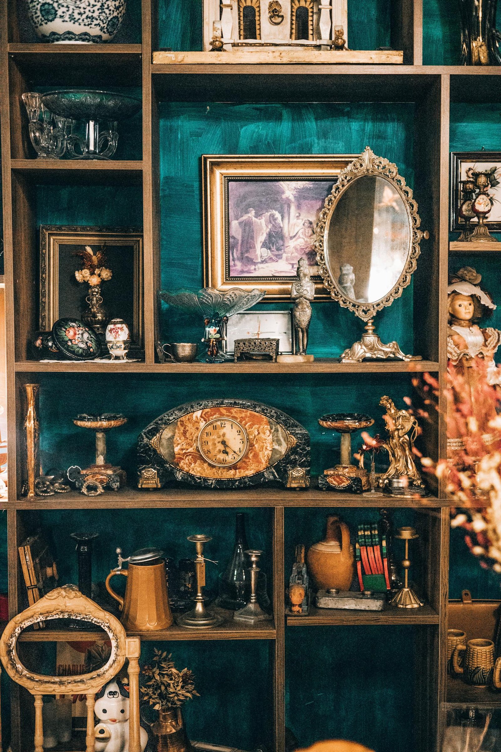 A curated display of antique items on ornate wooden shelves in an indoor setting.