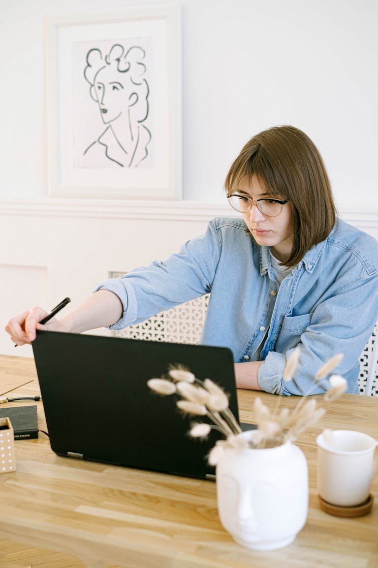 A woman in a home office working on her blog on a laptop, illustrating remote work lifestyle.