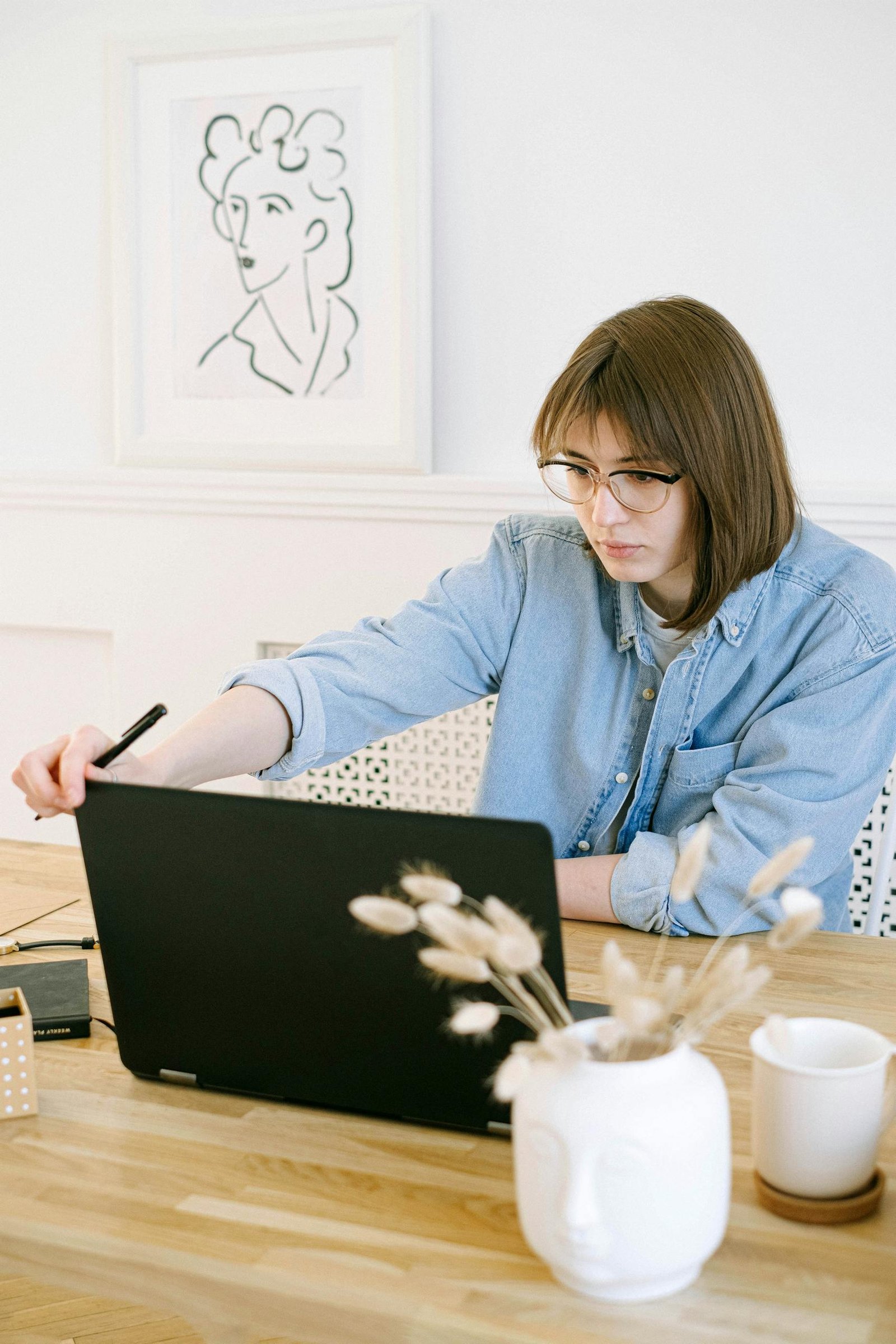 A woman in a home office working on her blog on a laptop, illustrating remote work lifestyle.