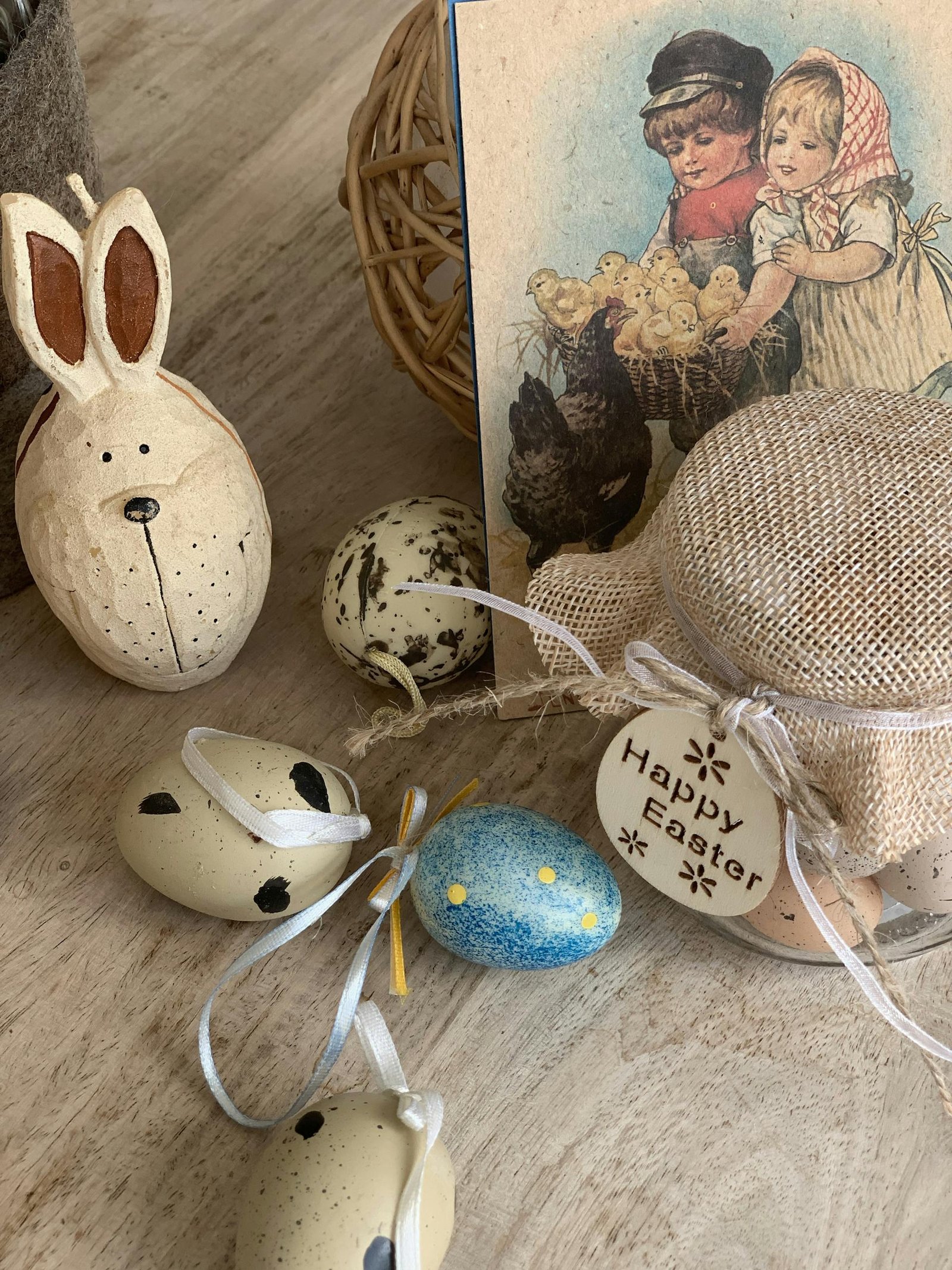 Easter-themed decorations include eggs, bunny, and a vintage card on a wooden surface.