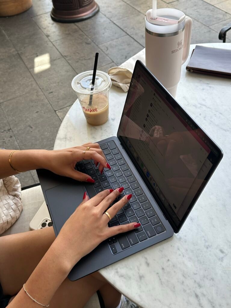 woman sitting at a cafe table and trying to finish the project she started