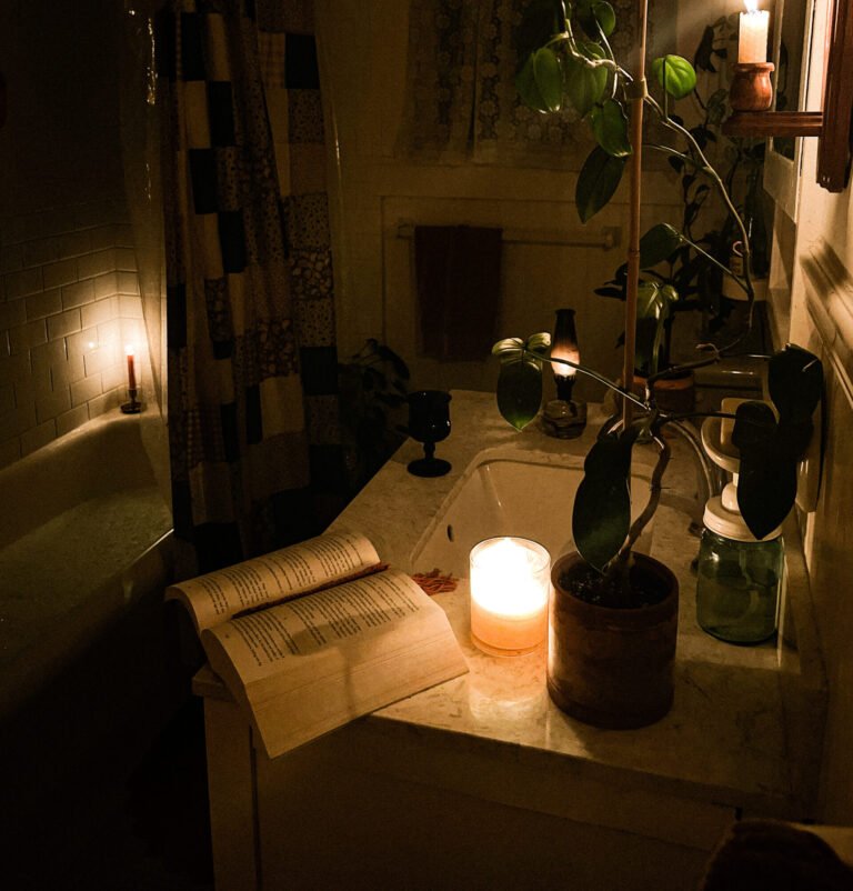 Open book in a candle lit bathroom showing how evening habits can make the morning easier.