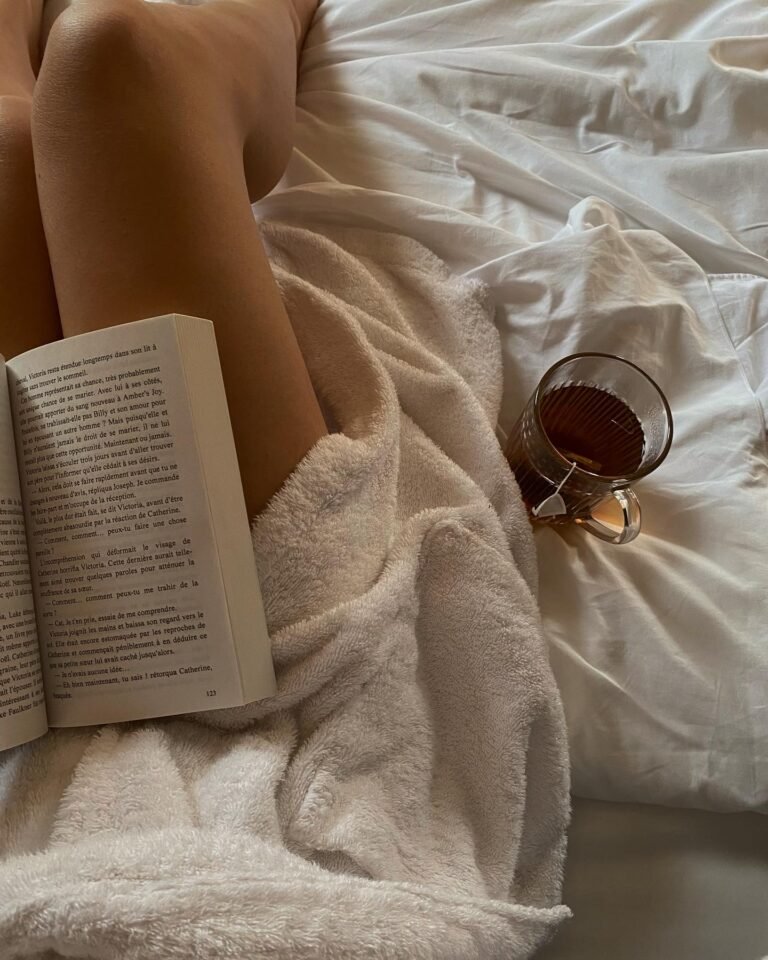 Woman reading in bed and having a tea as a part of her night routine without a phone